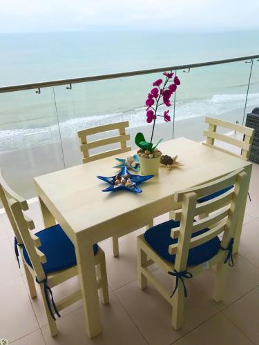 a table with two chairs and a table with flowers on it at Departamentos frente al mar in Tonsupa