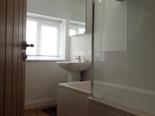 a bathroom with a sink and a glass shower at Modern Town Apartment with Terrace in West Kirby
