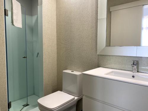 a bathroom with a toilet and a sink at Golden Beach Guest House & Rooftop Bar in Faro