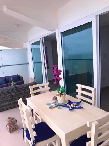 a white table with a vase with flowers on it at Departamentos frente al mar in Tonsupa