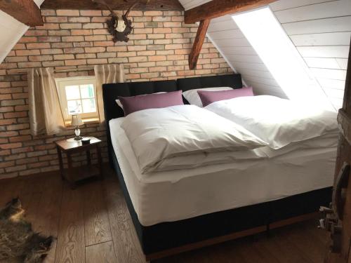 a bedroom with a large bed with a brick wall at Historisches Tagelöhnerhaus in Geisingen