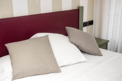 a bed with white pillows and a purple headboard at Boutique Hotel Castilla in Soria