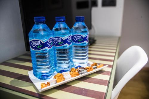 drie flessen water op een tafel met snacks bij Boutique Hotel Castilla in Soria