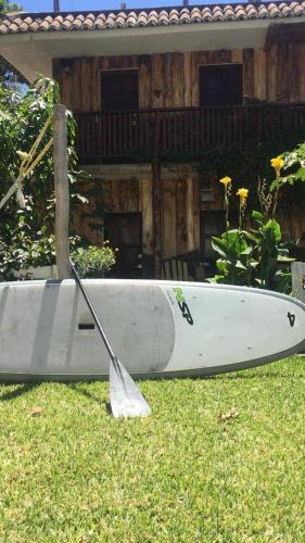 a white boat sitting on the grass in front of a house at Cabañas de Tzununa in Tzununá