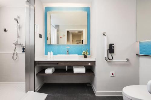 La salle de bains est pourvue d'un lavabo et d'un miroir. dans l'établissement Holiday Inn Express Foshan Chancheng, an IHG Hotel, à Foshan