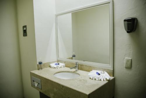 La salle de bains est pourvue d'un lavabo et d'un grand miroir. dans l'établissement Hotel Tres Soles, à Ciudad Madero