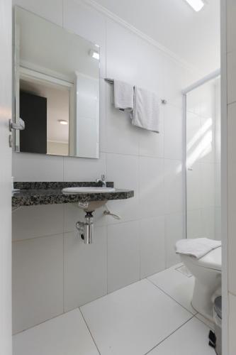a white bathroom with a sink and a toilet at Paulista Garden Hotel in São Paulo