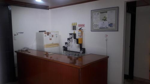 a counter with a refrigerator and a picture on a wall at Hospedaje Santa Bárbara in Buga