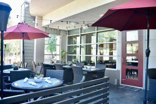 a restaurant with tables and chairs and umbrellas at Holiday Inn Windsor - Wine Country by IHG in Windsor
