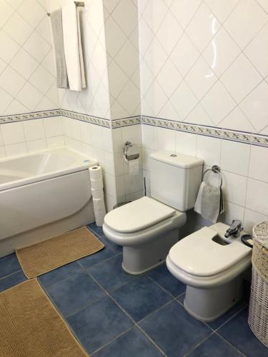 a bathroom with a toilet and a bidet and a bath tub at Galerias 90 in Pombal
