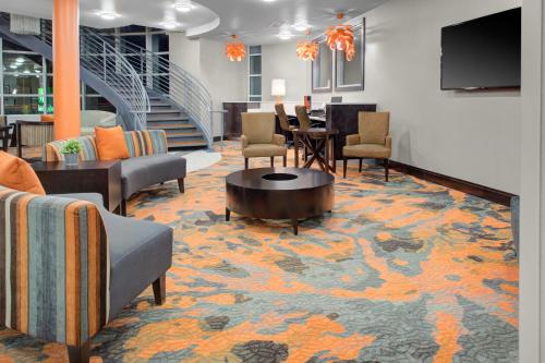 a lobby with chairs and a table and a television at Holiday Inn Windsor - Wine Country by IHG in Windsor