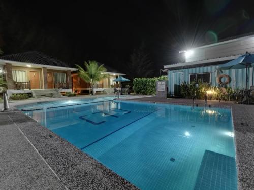 a swimming pool at night with a building at Casa Tanjung Jara in Dungun