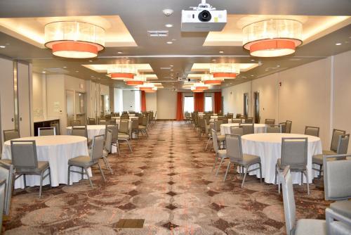 a banquet hall with white tables and chairs at Holiday Inn Windsor - Wine Country by IHG in Windsor