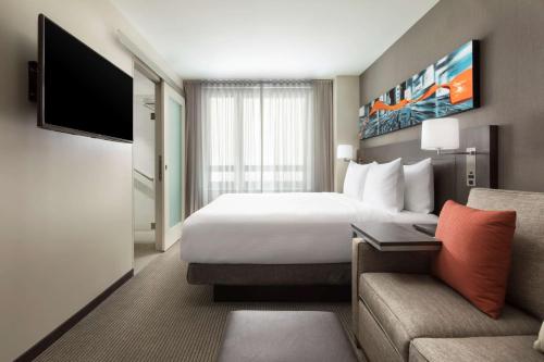 
a hotel room with a large bed and a television at Hyatt Place New York City/Times Square in New York
