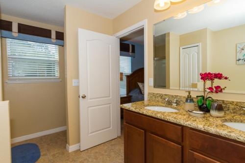 a bathroom with two sinks and a mirror at Tuscany at Westside Luxury 5 Bed, 4 Bath Villa near Disney in Kissimmee
