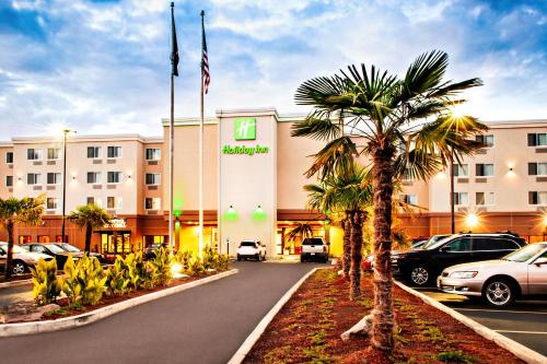 a hotel with a palm tree in front of a building at Holiday Inn - Salem by IHG in Salem