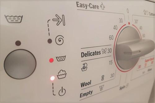 a washing machine with many stickers on a wall at Spitaki Apartments Potos in Potos