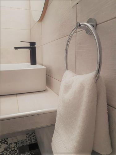a bathroom with a white towel hanging from a sink at Spitaki Apartments Potos in Potos