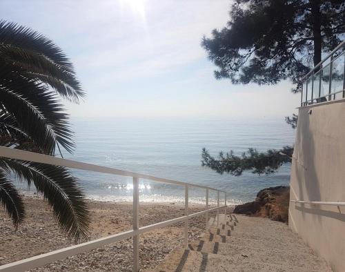 a view of a beach with a fence and the ocean at Spitaki Apartments Potos in Potos