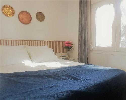a bedroom with a bed with blue sheets and a window at Spitaki Apartments Potos in Potos