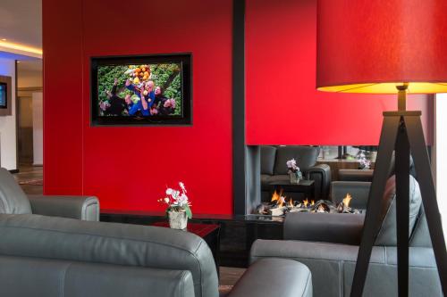 a living room with red walls and a fire place at Bastion Hotel Amsterdam Airport in Hoofddorp