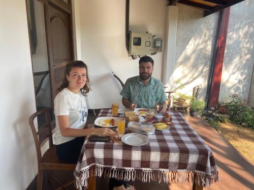 a man and a woman sitting at a table with food at White Lodge in Kandy