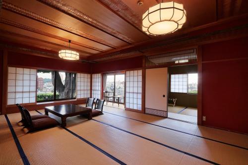 a room with a table and chairs and windows at Yamanoo in Kanazawa