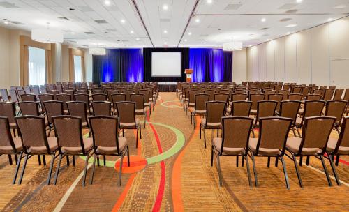 a conference room with chairs and a screen at Holiday Inn San Jose-Silicon Valley by IHG in San Jose
