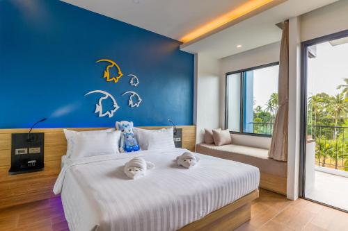 a bedroom with a large bed with a blue wall at Anda Sea Tales Resort-SHA Plus in Ao Nang Beach