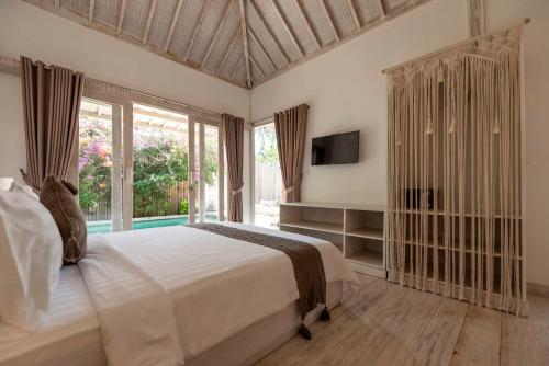 a bedroom with a large bed and a large window at Villas Edenia in Gili Trawangan