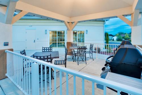 a balcony with a table and chairs and a grill at Candlewood Suites Harrisburg I-81 Hershey Area by IHG in Harrisburg