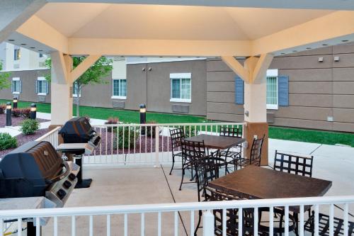 a patio with a table and chairs and a grill at Candlewood Suites Harrisburg I-81 Hershey Area by IHG in Harrisburg
