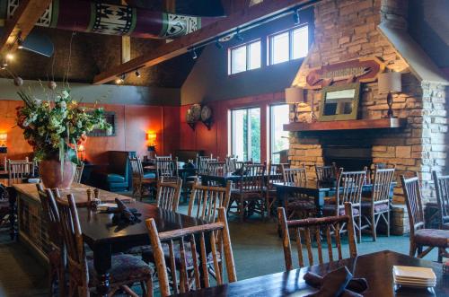 a restaurant with tables and chairs and a fireplace at Holiday Inn Hotel Pewaukee-Milwaukee West by IHG in Pewaukee