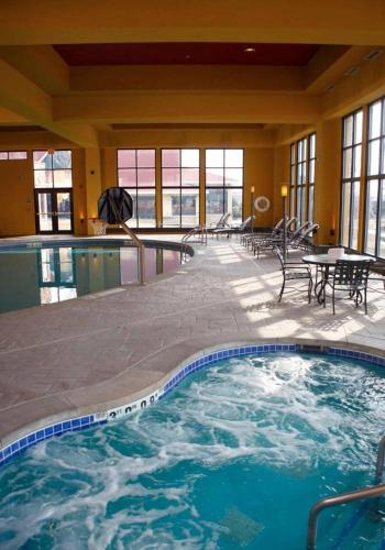 a large pool in a hotel with a table and chairs at Holiday Inn Hotel Pewaukee-Milwaukee West by IHG in Pewaukee