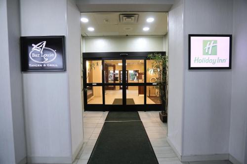 a hallway of a shopping mall with a door open at Holiday Inn O'Hare Area by IHG in Rosemont