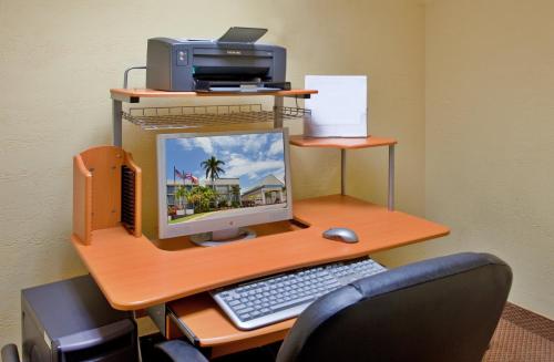 a computer desk with a keyboard, mouse and monitor at Holiday Inn Ponce & El Tropical Casino, an IHG Hotel in Ponce