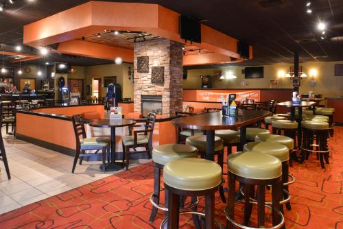 a restaurant with tables and chairs and a bar at Ramada Plaza by Wyndham Sheridan Hotel & Convention Center in Sheridan