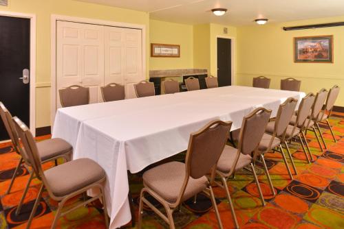 a conference room with a white table and chairs at Ramada Plaza by Wyndham Sheridan Hotel & Convention Center in Sheridan
