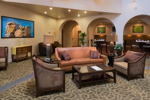 a hotel lobby with a couch and tables and chairs at GreenTree Hotel Phoenix West in Phoenix