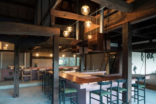 a large room with a bar with stools at ume, in Yamazoe