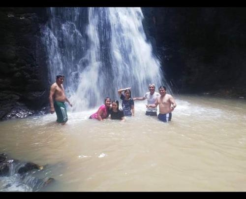 a group of people standing in the water in front of a waterfall at Hospedaje Independencia Pucallpa in Pucallpa
