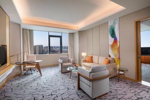 a living room with a couch and a television at Holiday Inn Tianjin Xiqing by IHG in Tianjin