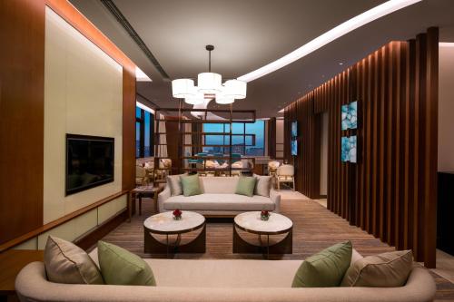 a living room with two couches and a tv at Holiday Inn Tianjin Xiqing, an IHG Hotel in Tianjin