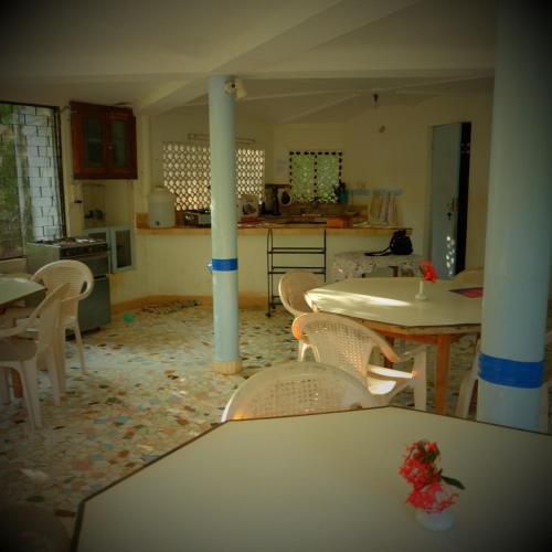 a kitchen and dining room with tables and chairs at New Creation Guest House in Auroville