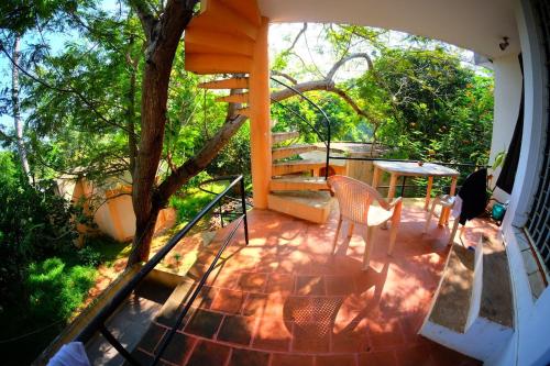 a balcony of a house with a table and chairs at New Creation Guest House in Auroville