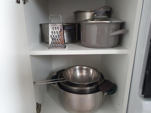 a kitchen shelf with pots and pans and a scale at Stella in Sanok