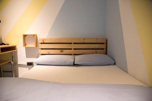 a bedroom with a bed with a wooden headboard at 框框背包客棧 Kuang Kuang Hostel in Longjing