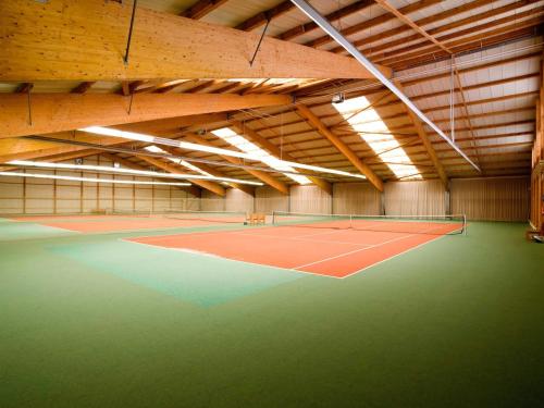 a tennis court in a building with a tennis court at IDINGSHOF Hotel & Restaurant in Bramsche