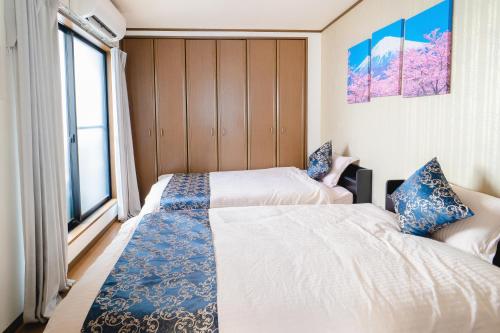 大阪市にある遊泊昭和町YupaStayの窓のある小さな部屋にベッドが2つある
