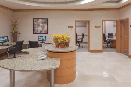 an office lobby with a reception counter with flowers on it at Crowne Plaza Torreon by IHG in Torreón